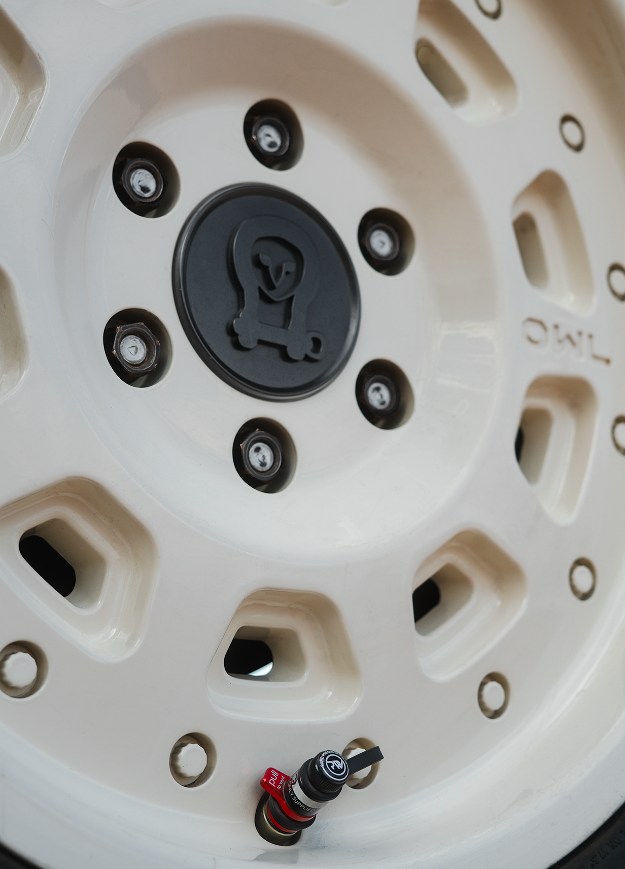 Close-up of a beige off-road vehicle wheel equipped with XL Rapid Deflator Valve for quick tire pressure adjustment.