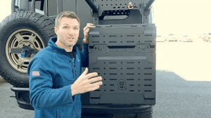 Man demonstrating the blacked-out Monster Box 30 cargo box mounted on a Sprinter Van bike rack.