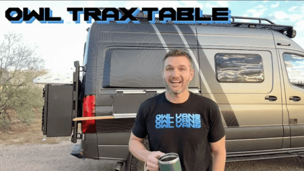 Man standing next to a Sprinter Van with the Owl Trax Table extended from the van's side.