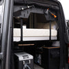 ULTRA Luxe Mattress installed inside a van with cozy bedding and organized storage beneath, designed for van life comfort and quality sleep.