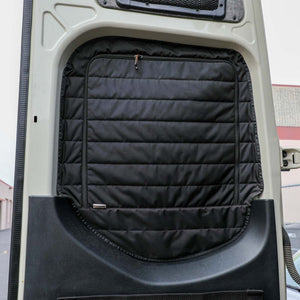 Insulated black Sprinter rear window cover with zippered airflow access installed on van door interior