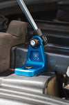 Blue anodized billet aluminum mount of Sprinter Hood Strut Kit installed under hood