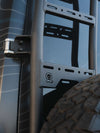 Close-up of black aluminum Sprinter tire carrier and ladder system mounted on rear door of 2019+ Sprinter van showing rugged tire and durable powder coat finish