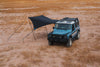Owl x Dragonfly HAKU Tarp attached to INEOS Grenadier providing shade and rain protection in a desert setting