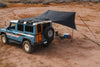 Owl x Dragonfly HAKU Tarp attached to INEOS Grenadier providing shelter in desert campsite