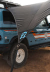 Owl x Dragonfly HAKU Tarp attached to INEOS Grenadier providing lightweight shelter and extra space.