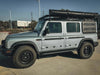 Silver INEOS Grenadier with Leitner Designs Side Kick Grenadier Accessory Panel mounted on the rear side for off-road utility and durability