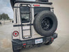 Leitner Designs Grenadier Euro Tire Relocation Bracket mounted on rear of off-road vehicle with tire and ladder.
