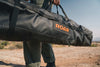 Outer Limits Camp Chair in black rugged carrying bag with ROAM logo being carried outdoors
