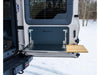 Folding tailgate table mounted on INEOS Grenadier with metal and wooden surface in snowy outdoor setting