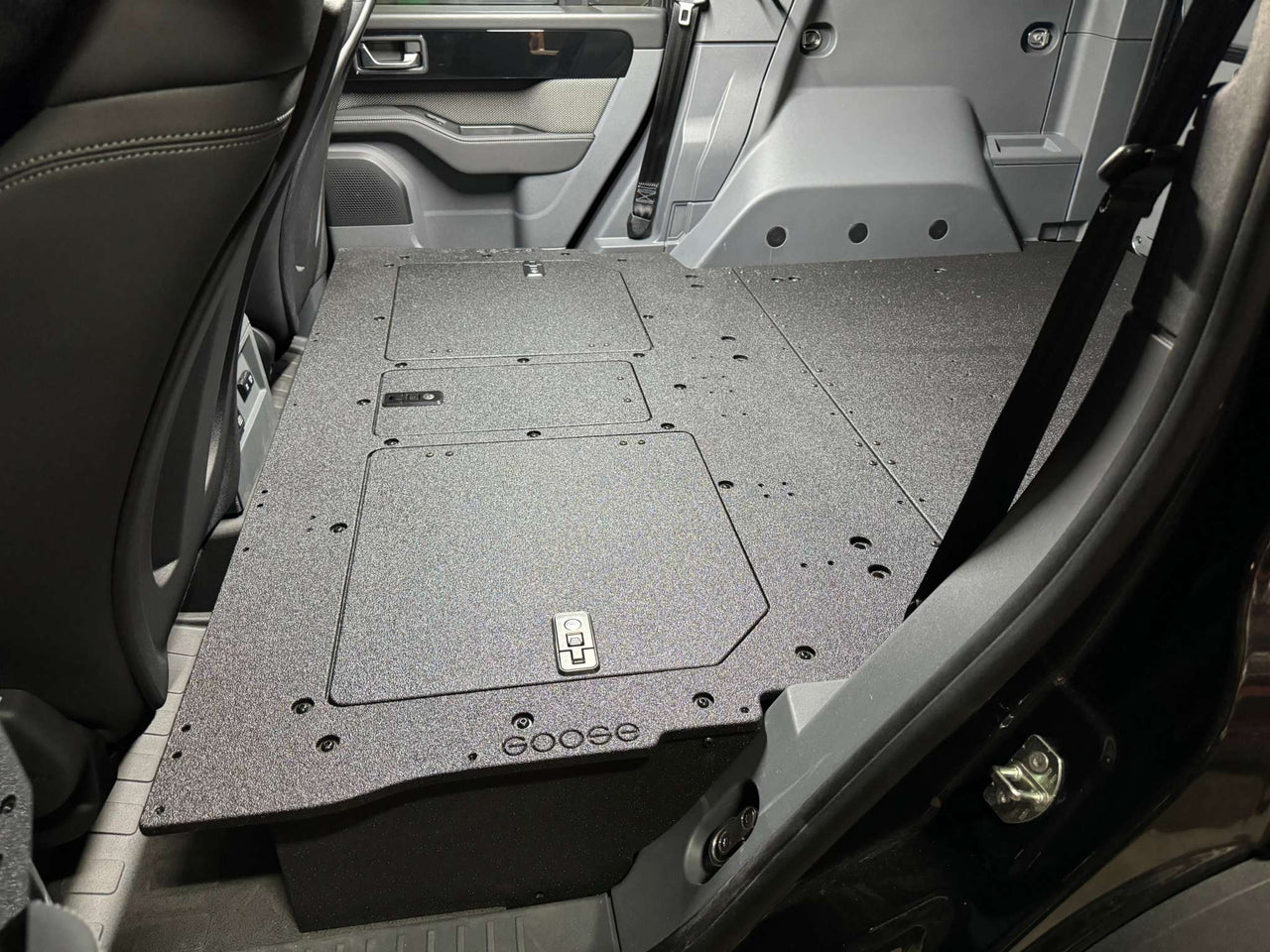 Explore Series Second Row Seat Delete Plate System installed in vehicle with access hatches and flat surface for easy