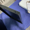 Black metal mounting bracket for Large Classic Cargo Box on blue padded surface