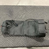 Black durable water-resistant seatback small trash bag with straps and roll-top closure laid flat on gray quilted surface