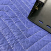 Black powder-coated metal bracket for Sprinter Headliner Shelf installation on blue quilted surface