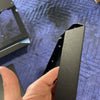 Black powder-coated billet aluminum seat back locker for Sprinter vehicle, held in hand on padded surface