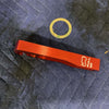 Red Grenadier Hood Release Handle with pull instruction symbol on a dark padded surface