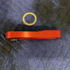 Red Grenadier Hood Release Handle with adhesive gasket on quilted black fabric background