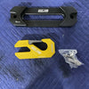 Yellow Mojab indexing fairlead hook and black fairlead plate with mounting hardware on blue quilted surface
