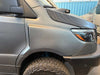 Close-up of a matte black Sprinter van front fender with rugged Sprinter Trail Fender Flares and off-road tire.