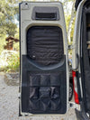 Insulated Sprinter rear window cover with zippered access and storage pockets on van door interior