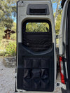 Insulated black Sprinter rear window cover with zipper and storage pockets attached to van door interior