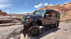 Owl Grenadier Steering Stabilizer installed on off-road Grenadier vehicle driving on rocky terrain