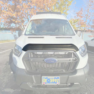 Front view of a white 2021+ Ford Transit van equipped with a black Terrawagen Aero Hood Spoiler under bright daylight