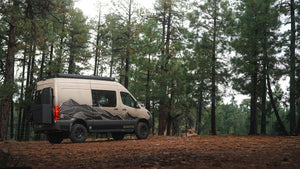 Owl x VanCraft Wasatch Halo Sprinter van with mountain design parked in forest camping setting