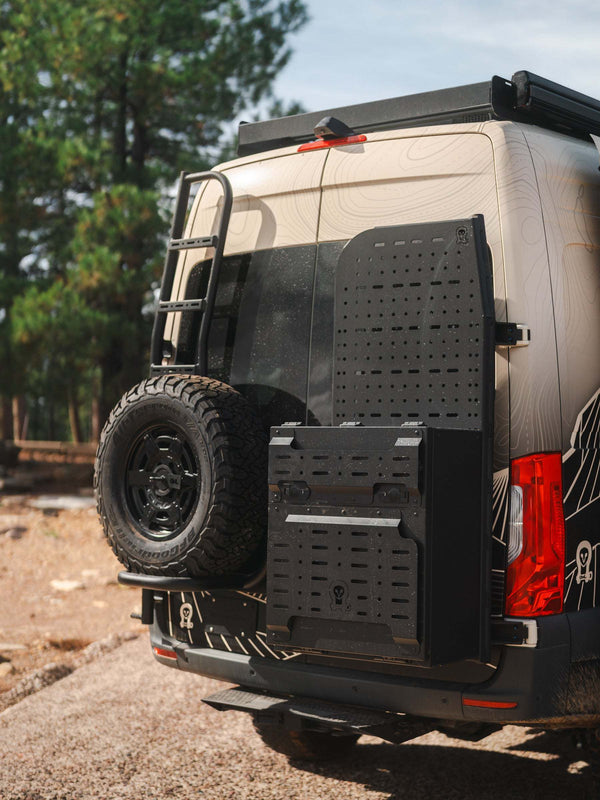 Owl x VanCraft Wasatch Halo Sprinter van rear with spare tire and accessory mounts in outdoor setting