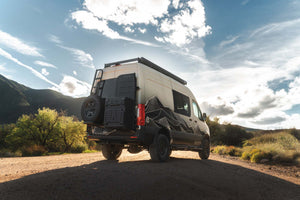 Owl x VanCraft Wasatch Halo Sprinter van with mountain design parked outdoors under blue sky
