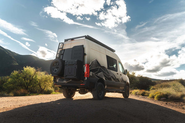 Owl x VanCraft Wasatch Halo Sprinter van with mountain design parked outdoors under blue sky
