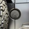 Machined aluminum rear door emblem with laser engraving on Sprinter van near oversized tire