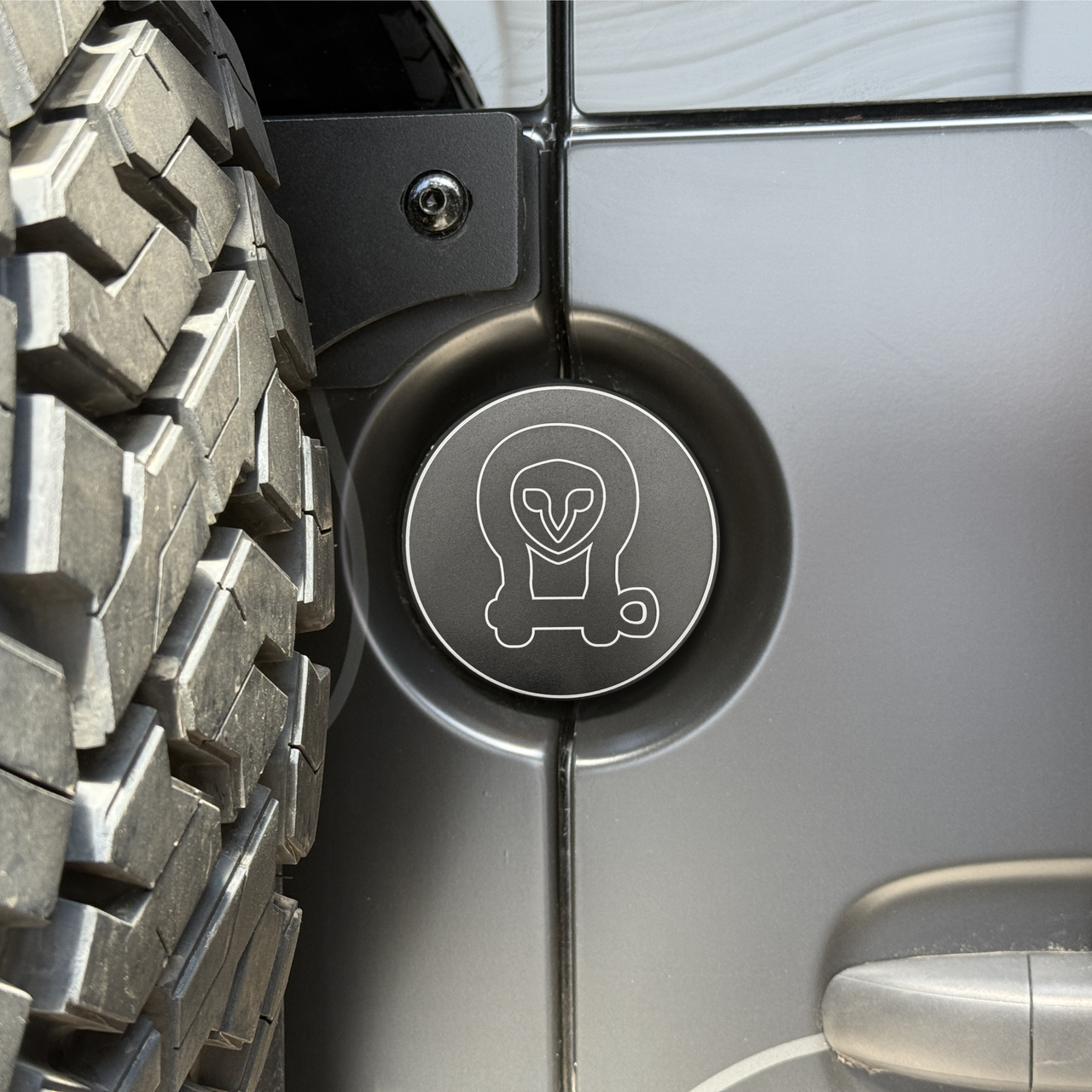 Machined aluminum rear door emblem with laser engraving on Sprinter van near oversized tire