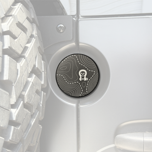 Machined aluminum rear door emblem with laser engraving on Sprinter van, designed for oversized tire clearance and factory mounting.