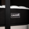 Close-up of ULTRA Luxe Mattress by CAVANS designed for REVEL vans, featuring a soft quilted white top and black textured side with branded label.