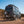 Black Sprinter van equipped with rear door Sprinter bike rack and box carrier driving on dirt road outdoors