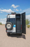 Open van storage box with shelves for skis, snowboards, and gear on a sunny day