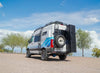 White and blue van with Alpine Box van storage box attached, designed for skis, snowboards, and golf gear storage outdoors