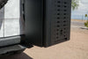 Black Alpine van storage box attached to side of camo-patterned vehicle for ski and snowboard gear storage