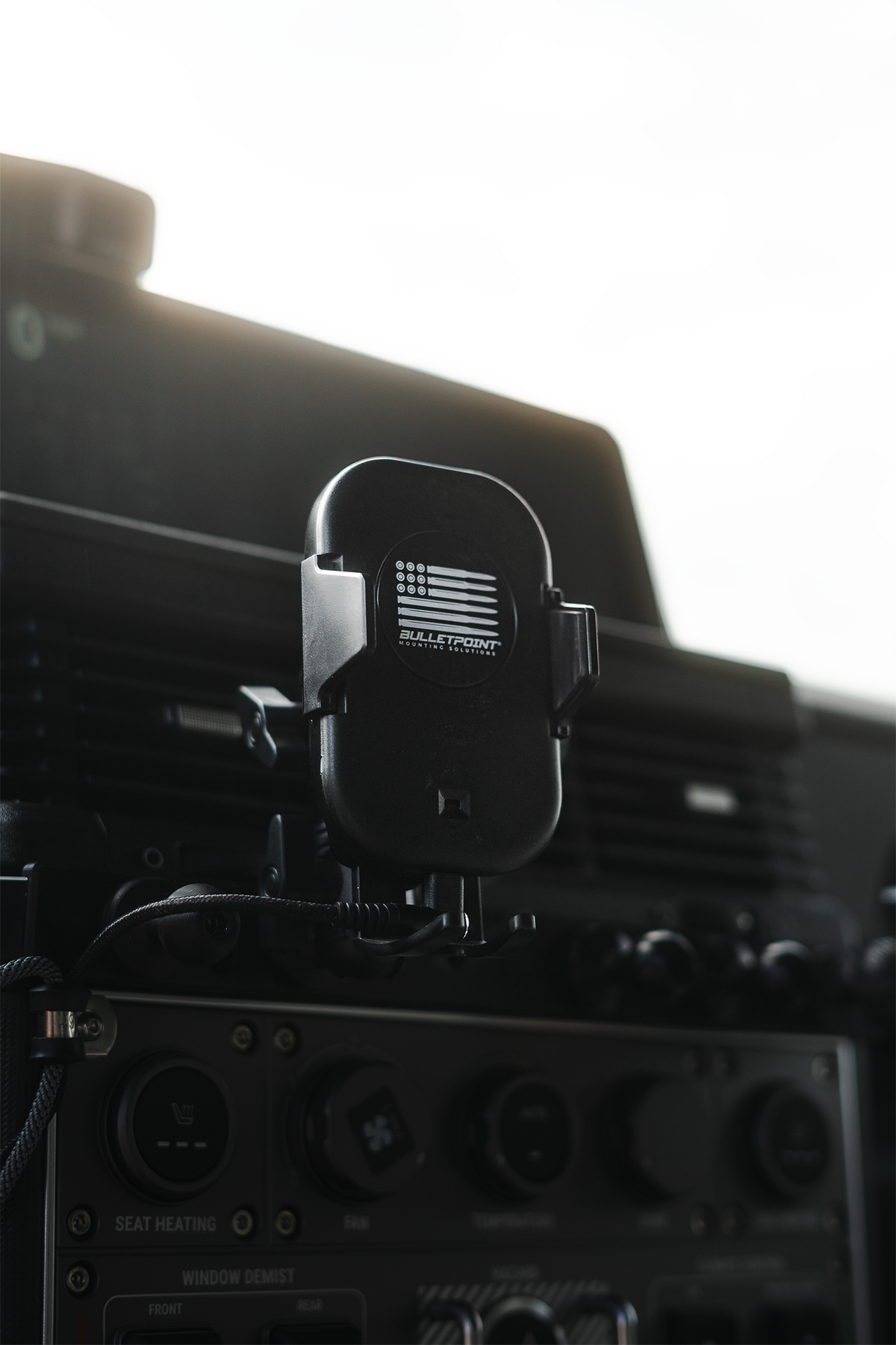 Wireless phone charger with motorized cradle mounted on vehicle dashboard