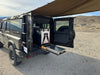 Grenadier Explore Series rear plate system with CampKitchen 2.2 and single drawer module storage in off-road vehicle in desert setting