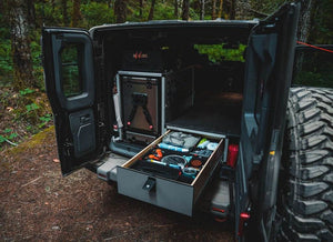 Explore Series Brian's Favorite Sleep Package with rear plate system, seat deletes, lockable drawer, CampKitchen 2.2, and pillow extension in a vehicle storage setup
