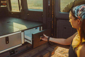 Person opening drawer refrigerator module in a vehicle overland setup