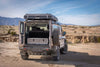Grenadier vehicle with open rear showing installed Side X Side Drawer Module in off-road desert setting