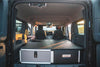 Explore Series Stealth Sleep & Chef Package vehicle interior with rear plate system, seat delete storage modules, lockable drawer, and Dometic fridge drawer for overland adventure storage and sleeping setup