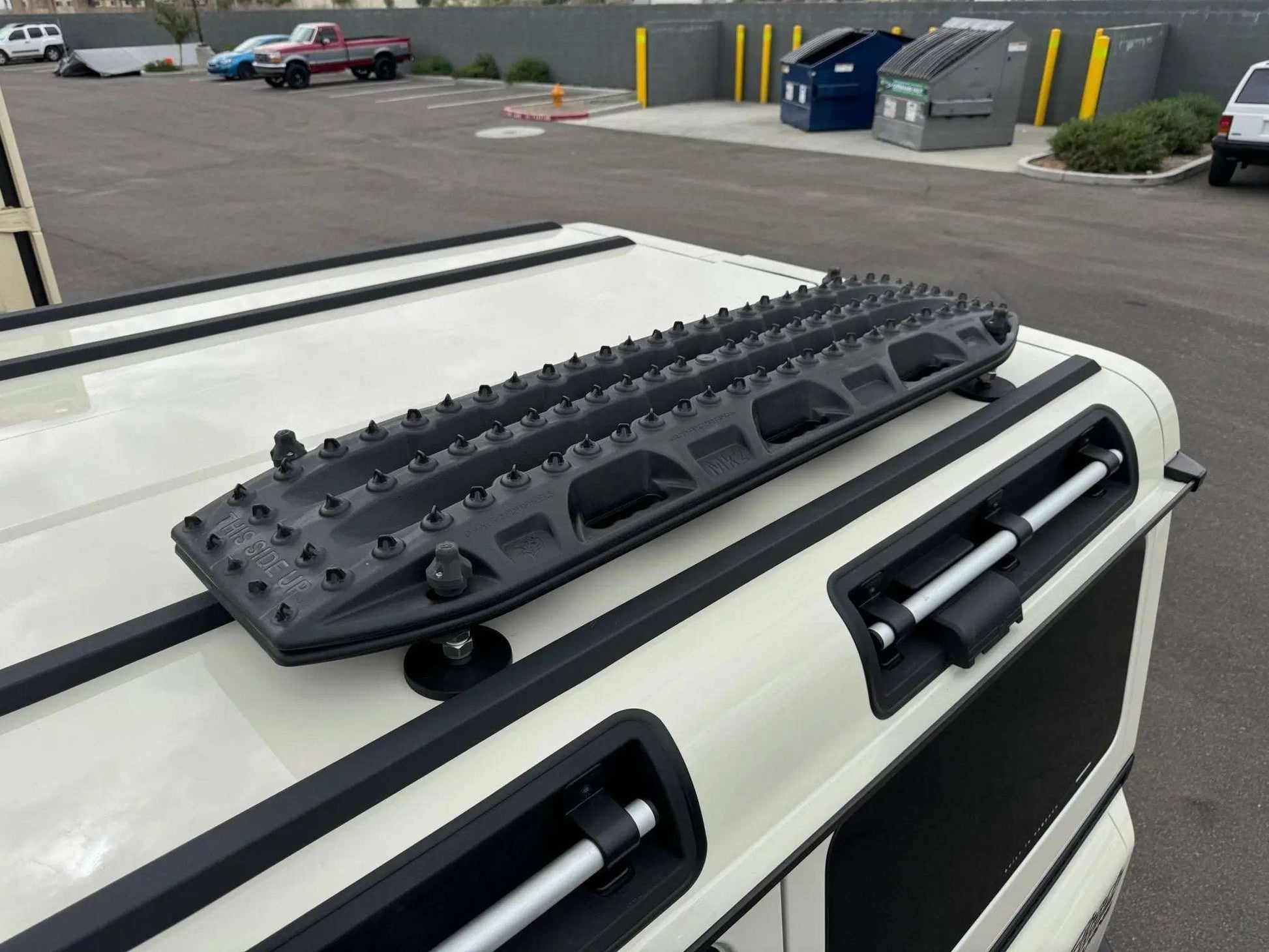 MKII Traction Boards mounted on vehicle roof, ideal for off-road recovery.