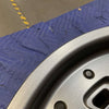 Graphite grey Owl Talon Sprinter wheel with minor scuffs, shown against a quilted surface.