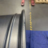 Close-up of a graphite grey Talon Transit AWD wheel rim with minor scuffs and scratches, showing a smooth aluminum finish.