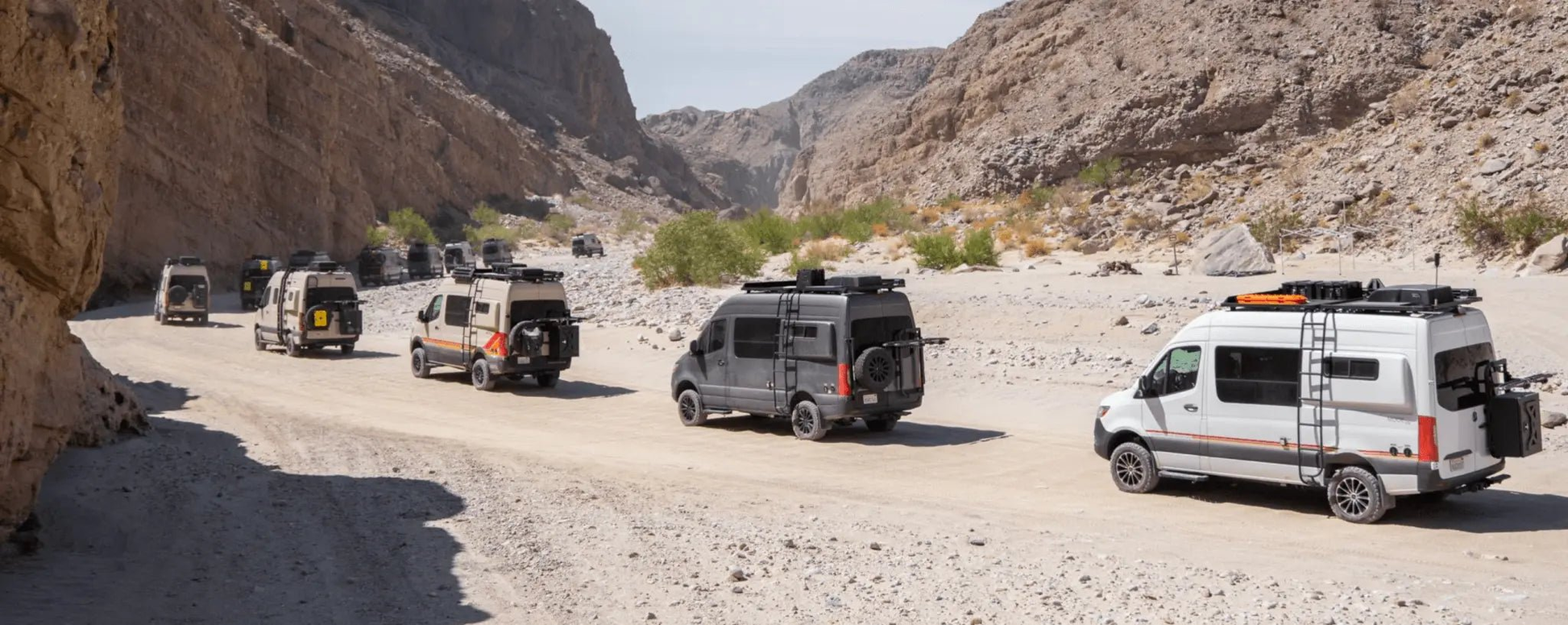 Bike racks on Sprinter vans in a desert setting.