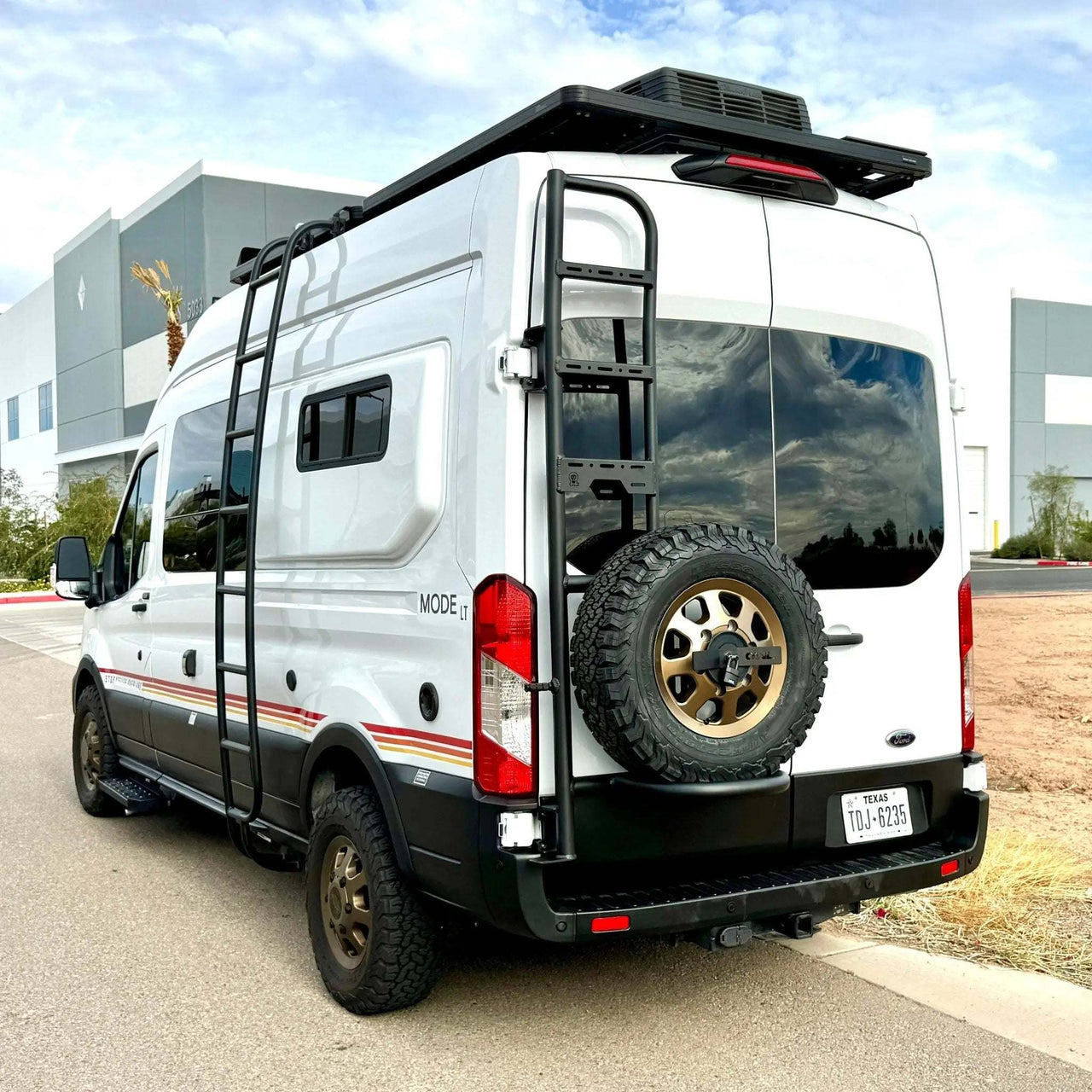 Full vehicle view of a Ford Transit with the Owl Ladder Tire carrier mounted on the rear doors